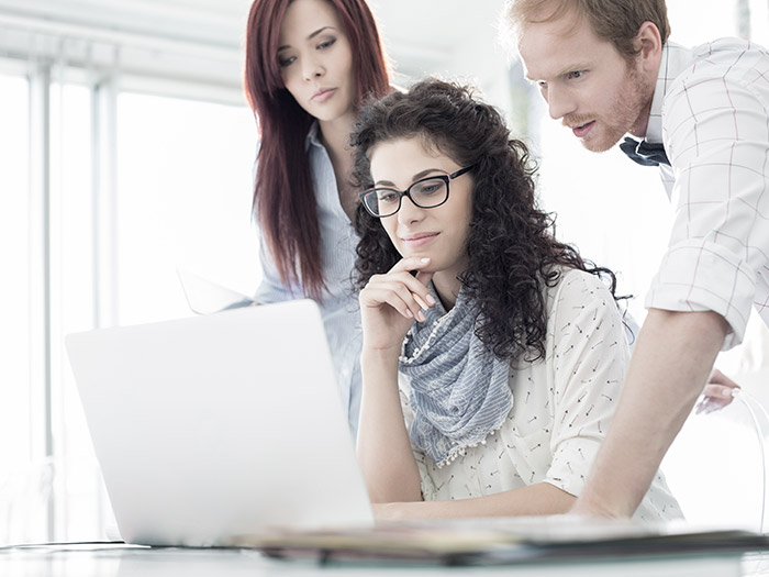 Business people looking at laptop | Atradius